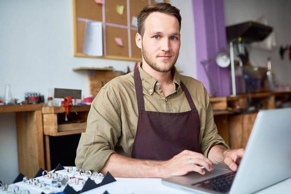 Male jeweler working at a laptop
