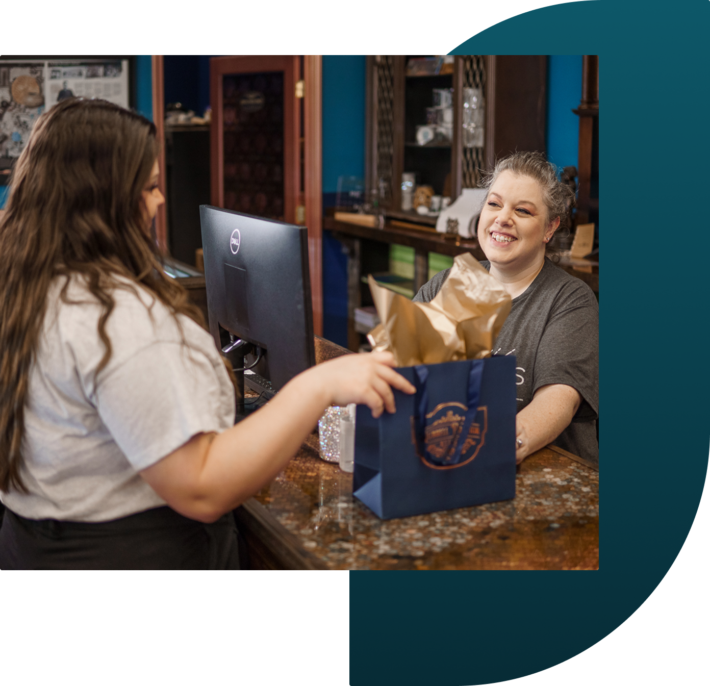 A jewelry store associate smiles at a customer during checkout.
